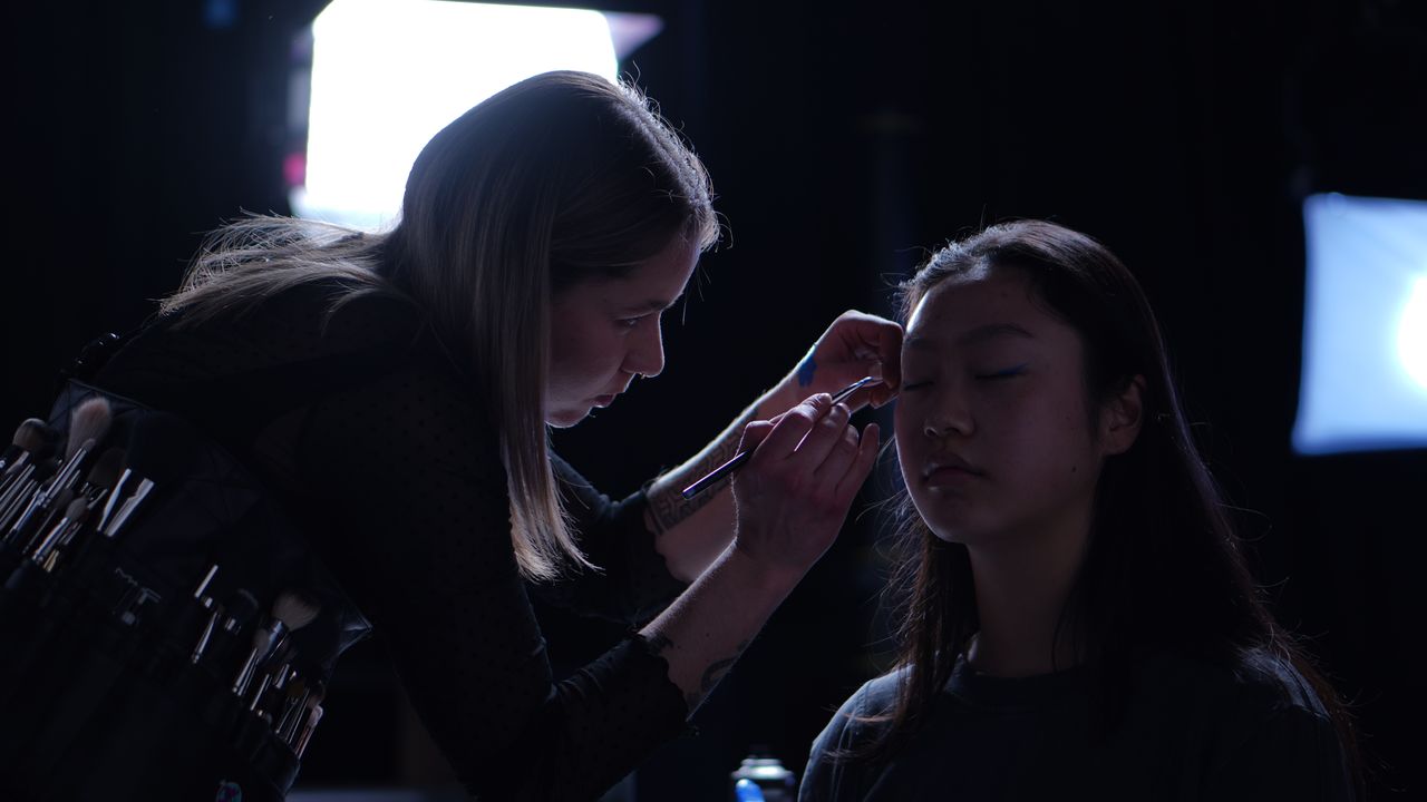 Tatjana schminkt backstage ein Model
